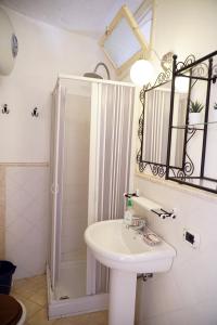 bagno bianco con lavandino e doccia di Casa Vacanze Irene a Scalea