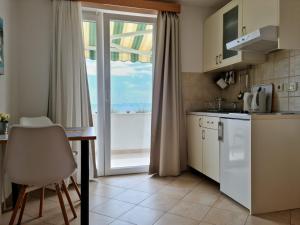 une petite cuisine avec une table et une fenêtre dans l'établissement New studio apartment with sea view, à Makarska 35 autres photos