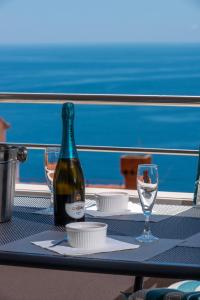 a bottle of wine sitting on a table with two glasses at Apartment Tonka in Cavtat