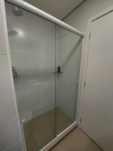 una puerta de ducha de cristal en una habitación en Flat Completo en Cotia
