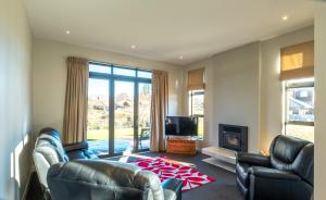 sala de estar con 2 sillas de cuero y chimenea en 13 St James Avenue, en Hanmer Springs