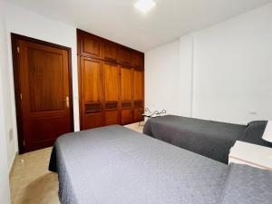 1 dormitorio con 1 cama y puerta de madera en Casa Josefa 3 en Caleta de Sebo