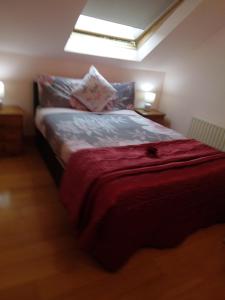 een slaapkamer met een bed met een rode deken bij Wild Atlantic Stays in Castlemaine