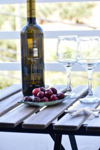 a bottle of wine and two glasses on a table at Charm Hotel, Hersonissos in Hersonissos