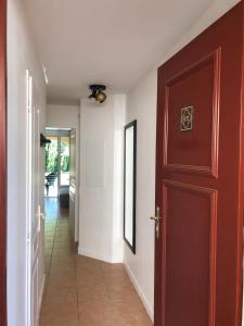 a hallway with a red door and a hallwayngth at Bonheur in Monflanquin