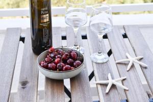 a bowl of grapes and two wine glasses on a table at Charm Hotel, Hersonissos in Hersonissos