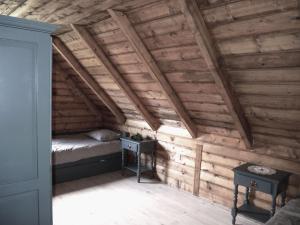 a bedroom with wooden walls and a bed and two tables at Chalet Lily in Žabljak