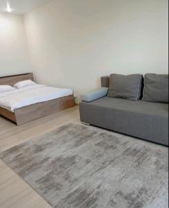 Habitación con 2 camas, sofá y alfombra. en Квартира в новобудові en Luts'k