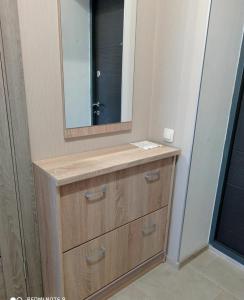 uma casa de banho com um lavatório de madeira e um espelho em Квартира в новобудові em Lutsk