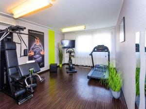 ein Zimmer mit einem Fitnessraum mit Laufband und Trainingsgeräten in der Unterkunft Ibis Styles Linz in Linz