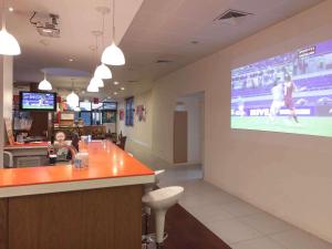 a restaurant with a large screen on the wall at Hotel ibis Faro Algarve in Faro