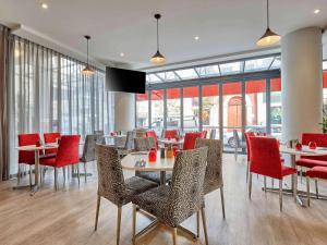 a dining room with tables and chairs and windows at ibis Perth in Perth