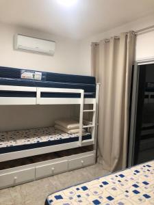 a bedroom with two bunk beds and a curtain at Casa em Condomínio Maresias in São Sebastião