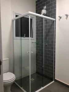 a glass shower in a bathroom with a toilet at Casa em Condomínio Maresias in São Sebastião