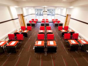 a dining room with red chairs and tables at Ibis Kaliningrad Center in Kaliningrad