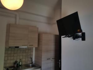 a kitchen with a television on top of a refrigerator at Alexandros in Kamena Vourla