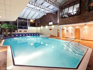 a large swimming pool in a building at Mercure Bolton Georgian House Hotel in Bolton