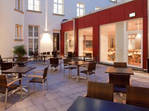 カールスルーエにあるイビス カールスルーエ ハウフトバーンホフ のテーブルと椅子、窓のあるレストラン