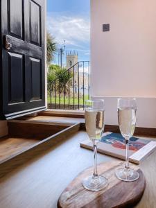 dois copos de vinho branco sentados numa mesa em 14-16 Grosvenor Street Luxury Apartments - Chester em Chester