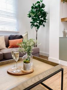 14-16 Grosvenor Street Luxury Apartments - Chester في تشيستر: طاولة قهوة مع أكواب ونبات الفخار