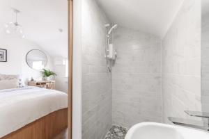 baño con ducha, cama y lavamanos en 14-16 Grosvenor Street Luxury Apartments - Chester, en Chester