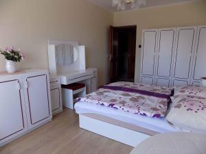 a white bedroom with a bed and a desk at Apartment Gyenesdias 3 in Gyenesdiás