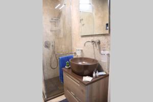 een badkamer met een koperen wastafel en een douche bij La casetta di Nonna Paola in Palazzolo Acreide