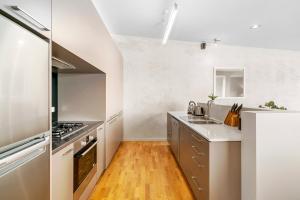 a kitchen with stainless steel appliances and wooden floors at Lomond Retreat - Near CBD Executive Apartment in Queenstown