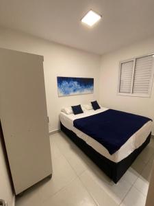 a bedroom with a large bed with a blue blanket at A37 Home Resort in Ubatuba