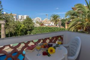 a balcony with a table with fruit and wine glasses at Palm Villa Estudios in Lagos