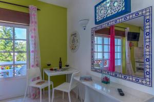 ラゴスにあるPalm Villa Estudiosの鏡、テーブル、椅子が備わる客室です。