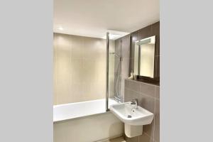 a bathroom with a sink and a bath tub at Luna Beach - Luxury Carbis Bay Apartment + Parking in Carbis Bay +12 photos