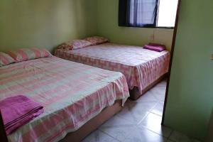 two beds in a room with pink and white sheets at CASA CON TODO LOS SERVICIOS Y 2 RECAMARAS CLIMATIZADAS CON 2 CAMAS CADA UNO PARA 8 PERSONAs in Tecolutla