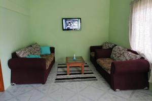 a living room with two couches and a coffee table at CASA CON TODO LOS SERVICIOS Y 2 RECAMARAS CLIMATIZADAS CON 2 CAMAS CADA UNO PARA 8 PERSONAs in Tecolutla
