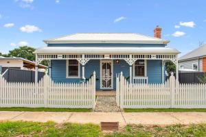 a blue house with a white picket fence at Blue House Bendigo in Bendigo