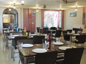 a dining room with tables and chairs with empty plates at New Orange Tree Classic Fall in Mussoorie with pool & parking in Mussoorie
