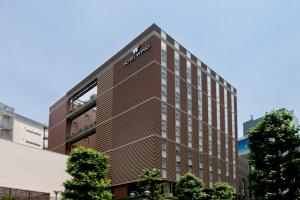 a tall brick building with a clock on the side of it at Hotel Wing International Premium Shibuya in Tokyo