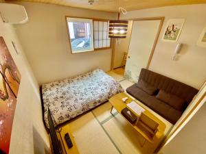 Habitación pequeña con sofá y mesa. en Hotel EL Shinjuku 6, en Tokio