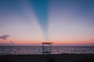 a umbrella on the beach at sunset at Casa Costa Suites in Kanali