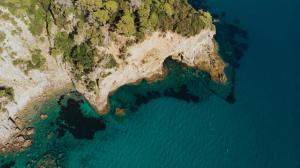 an island in the ocean next to the water at Casa Costa Suites in Kanali