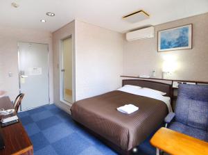 a hotel room with a bed and a desk and a chair at Royal Inn Kakegawa (Station Hotel 2) in Kakegawa