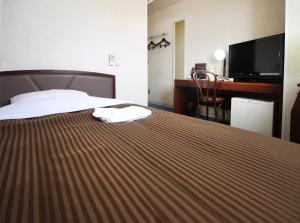 Pokój hotelowy z łóżkiem i biurkiem w obiekcie Royal Inn Kakegawa (Station Hotel 2) w mieście Kakegawa