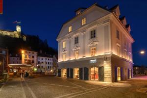 a large white building on a street at night at Zlata Ladjica Boutique Hotel in Ljubljana