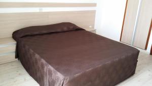 Cama marrón en habitación con ventana en Agrino Hotel Apartments, en Ayia Napa 2 fotos más