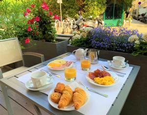 una mesa de desayuno con cruasanes, huevos revueltos y zumo de naranja en Hotel Boréal Nice en Niza