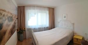 um quarto com uma cama branca e uma janela em Hillside Rooms em Pörtschach am Wörthersee