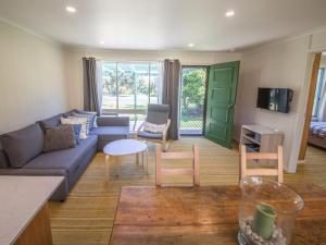 a living room with a couch and a table and chairs at 17 Broadbeach Drive in Normanville