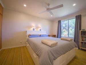 una camera con letto, ventilatore a soffitto e finestra di 17 Broadbeach Drive a Normanville