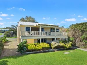 a house with a balcony and a yard at 22 Broadbeach Drive in Normanville