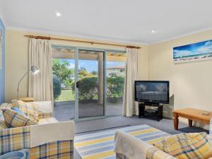 a living room with a couch and a television at 22 Broadbeach Drive in Normanville